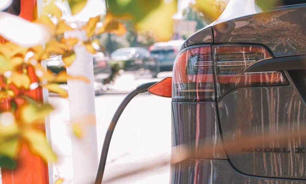 Detalle de un coche eléctrico conectado a una estación de carga.