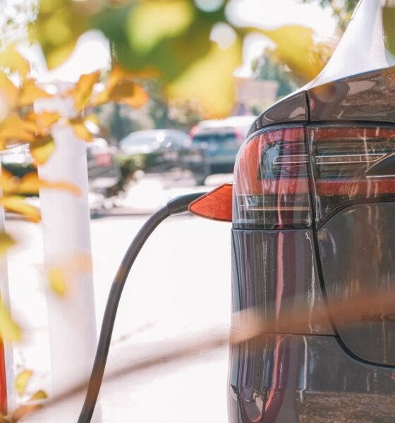 Detalle de un coche eléctrico conectado a una estación de carga.