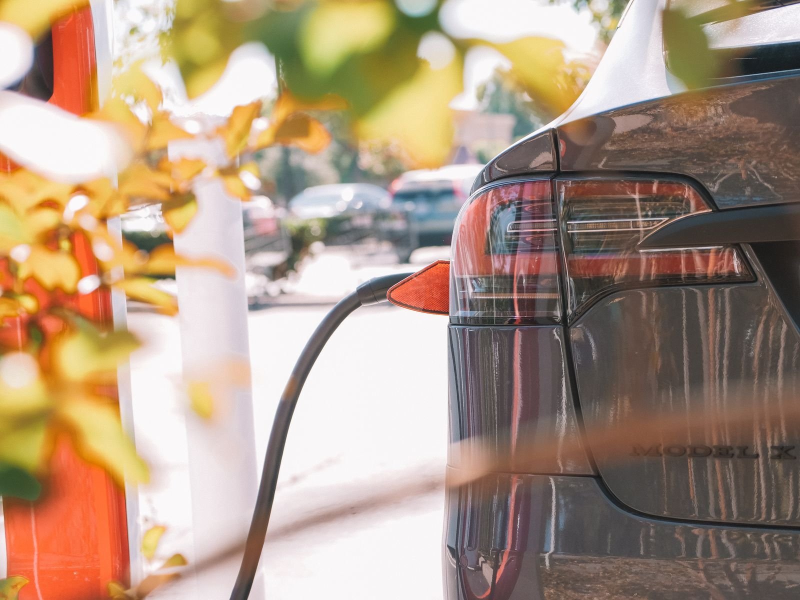 Detalle de un coche eléctrico conectado a una estación de carga.