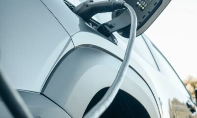 Detalle de un vehículo eléctrico conectado a un punto de recarga.