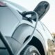Detalle de un vehículo eléctrico conectado a un punto de recarga.